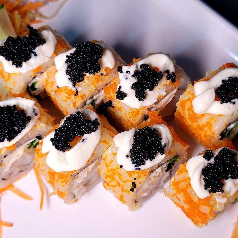 Uramaki com interior de peixe branco, e exterior com ovas capelin, finaliza com com cream cheese e ovas de masago.