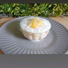 Desfrute da nossa deliciosa 'Torta de Abacaxi com Coco'. Cuidadosamente preparada com um cremoso e suave creme branco, combinado com pedaços de abacaxi natural, proporcionando um sabor fresco e vibrante. Acrescentamos camadas de biscoitos champanhe para adicionar uma textura crocante. Para finalizar, a torta é generosamente coberta com coco ralado, que acrescenta uma doçura tropical ao prato. Servida em um prático pote de 250ml, esta sobremesa é a oferta perfeita para satisfazer seus desejos doces.