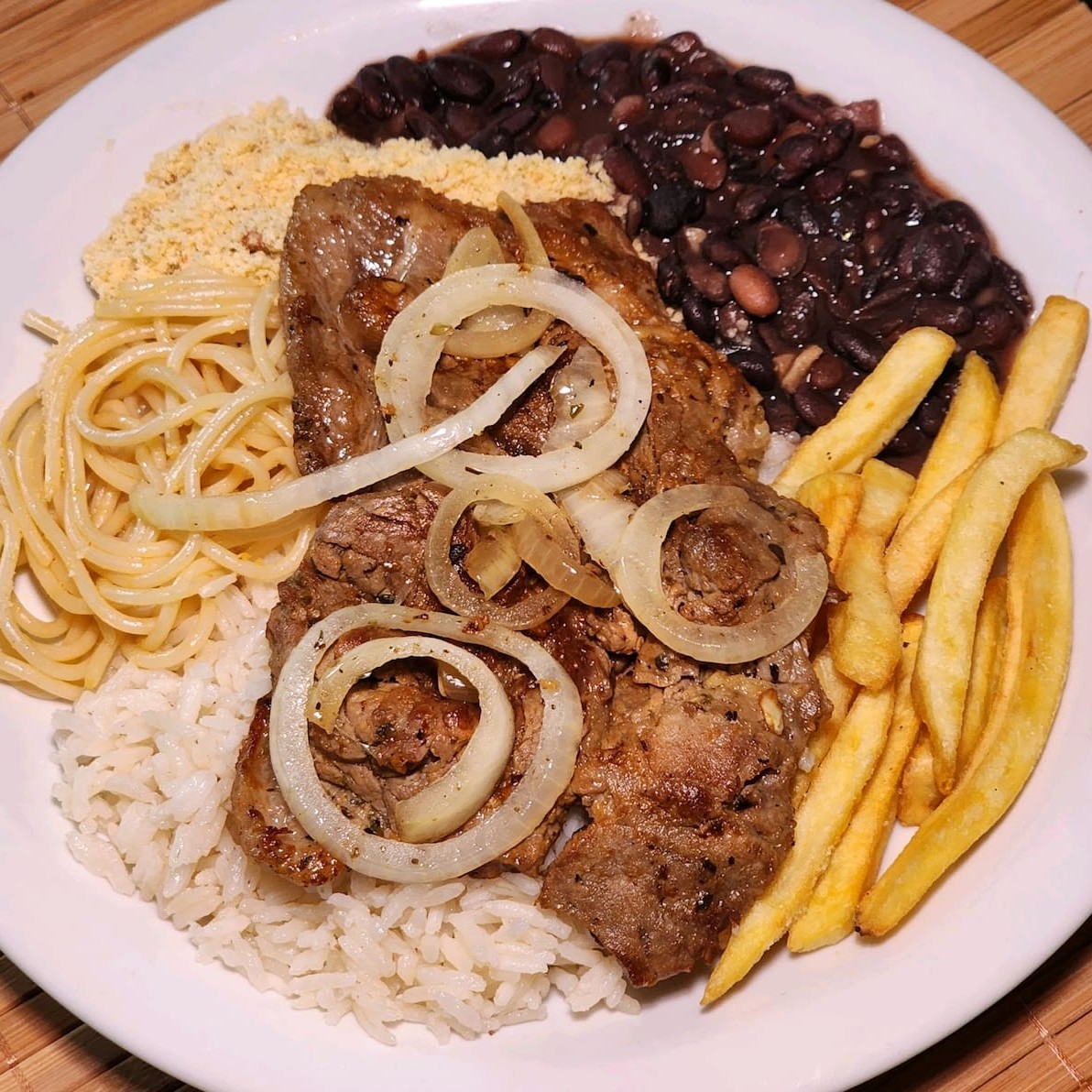 Inigualável 'Bife Acebolado da Sua Vida', uma oferta exclusiva entre os nossos mais vendidos. Com nosso corte de carne de primeira de contra filé premium. Você pode escolher entre um de nossos deliciosos acompanhamentos. Acompanhados de arroz branco soltinho, feijão preto temperado e cremoso, macarrão espaguete al dente com tempero caseiro e farofa crocante e sequinha.  (serve 1 pessoa)