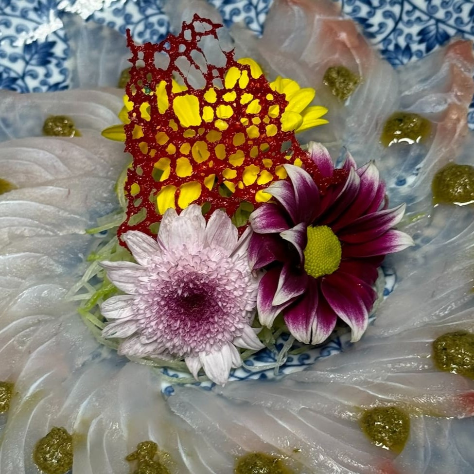 Saboreie a leveza e a frescura do nosso Carpaccio de Peixe do Dia com Pesto! São 20 lâminas finíssimas de peixe fresco, cuidadosamente selecionado, delicadamente temperadas e acompanhadas de um delicioso pesto feito com ervas frescas. Uma combinação perfeita entre o sabor suave do peixe e o frescor do molho pesto, proporcionando uma experiência sofisticada e de puro prazer. Ideal para quem aprecia