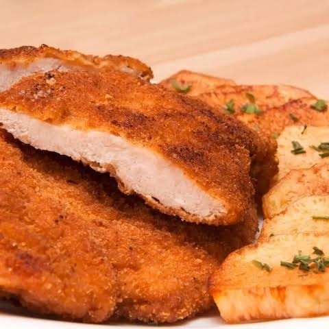 Apresentamos o nosso 'Filé de Frango à Milanesa', uma das estrelas da nossa categoria 'Refeição do Dia'. Este prato generosamente servido com dois pedaços de filé de frango, meticulosamente empanados e fritos até atingirem a perfeição dourada. Acompanha uma porção de arroz soltinho, feijão fresquinho, macarrão al dente e farofa crocante para adicionar uma textura diferenciada. Para completar, uma porção de batatas fritas, crocantes por fora e macias por dentro, e uma refrescante salada de alface e tomate, trazendo leveza e equilíbrio ao prato. Uma refeição completa e irresi