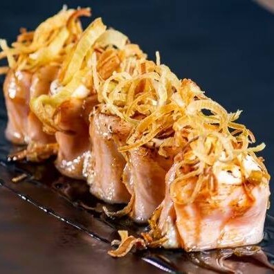 Enrolado de salmão com cream cheese, maçaricado e finalizado com molho teriaki e alho poró.

Enrolado de salmão com cream cheese delicadamente maçaricado, trazendo aquele sabor defumado e levemente tostado que destaca o frescor do salmão. Finalizado com um toque generoso de molho teriyaki adocicado e alho poró crocante, que acrescenta textura e um sabor marcante, esse prato é perfeito para quem busca uma experiência japonesa sofisticada e cheia de sabor.