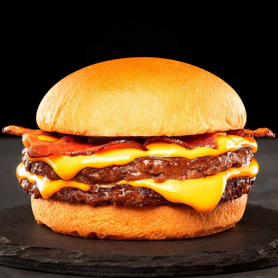 Pão, 2 Blend de 100g Prensado na chapa com aquela crostinha , Bacon em tiras defumado e o nosso cheddar cremoso artesanal.