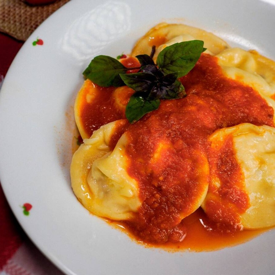 Delicados raviolis com um suave recheio de queijos brancos e ervas, cobertos pelo nosso levíssimo molho de tomate artesanal. Uma experiência de sabor fresca e equilibrada.