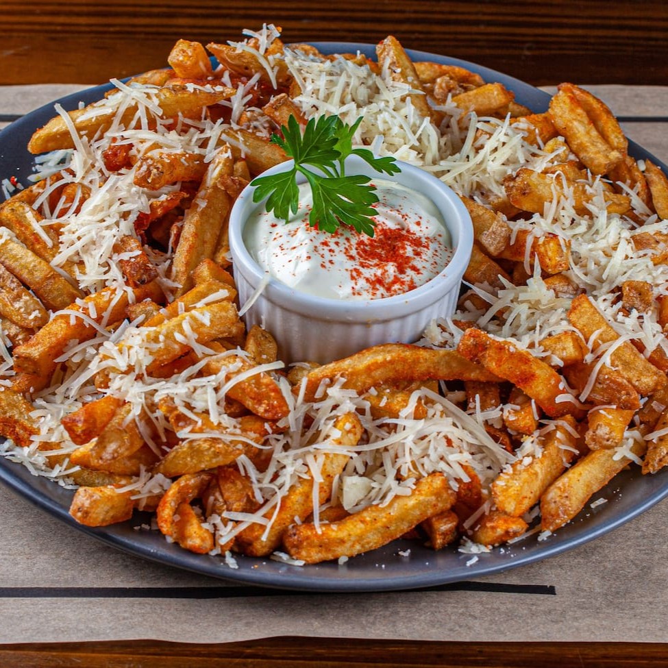 Fritas do cozi, temperadas com sal e páprica defumada, com neve de queijo parmesão e aioli caseiro.