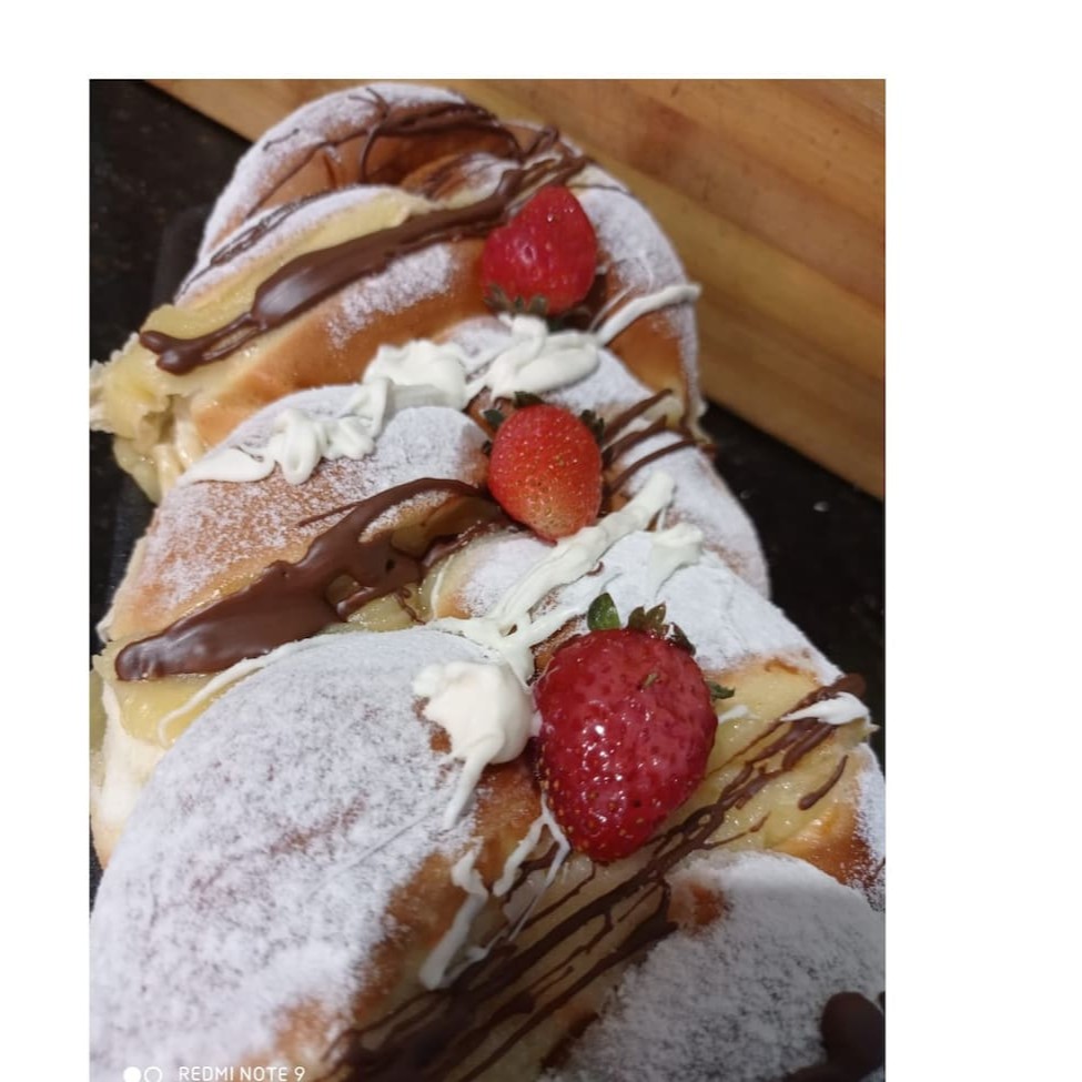 Saboreie nosso 'Pão Doce Grande Especial', pertencente à categoria 'Pão Francês, Pães Doces e Pães Especiais'. Esta delícia é composta por uma massa doce excepcionalmente macia e saborosa, que envolve uma seleção primorosa de frutas frescas. Para completar, é generosamente recheado com cremes suaves e decorado com uma variedade de confeitaria requintada. Este pão doce é a combinação perfeita de sabores e texturas que certamente irá encantar seu paladar!