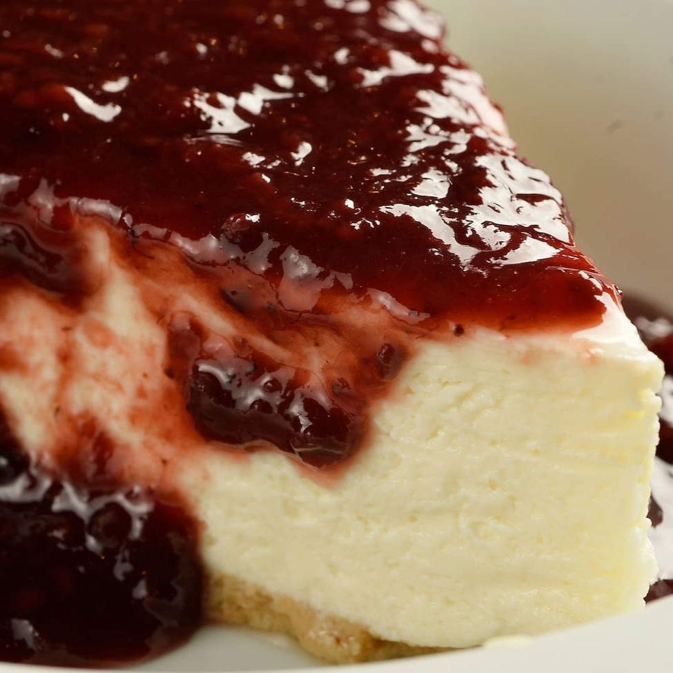 Cheesecake no estilo stadium, servido com a calda de frutas vermelhas.