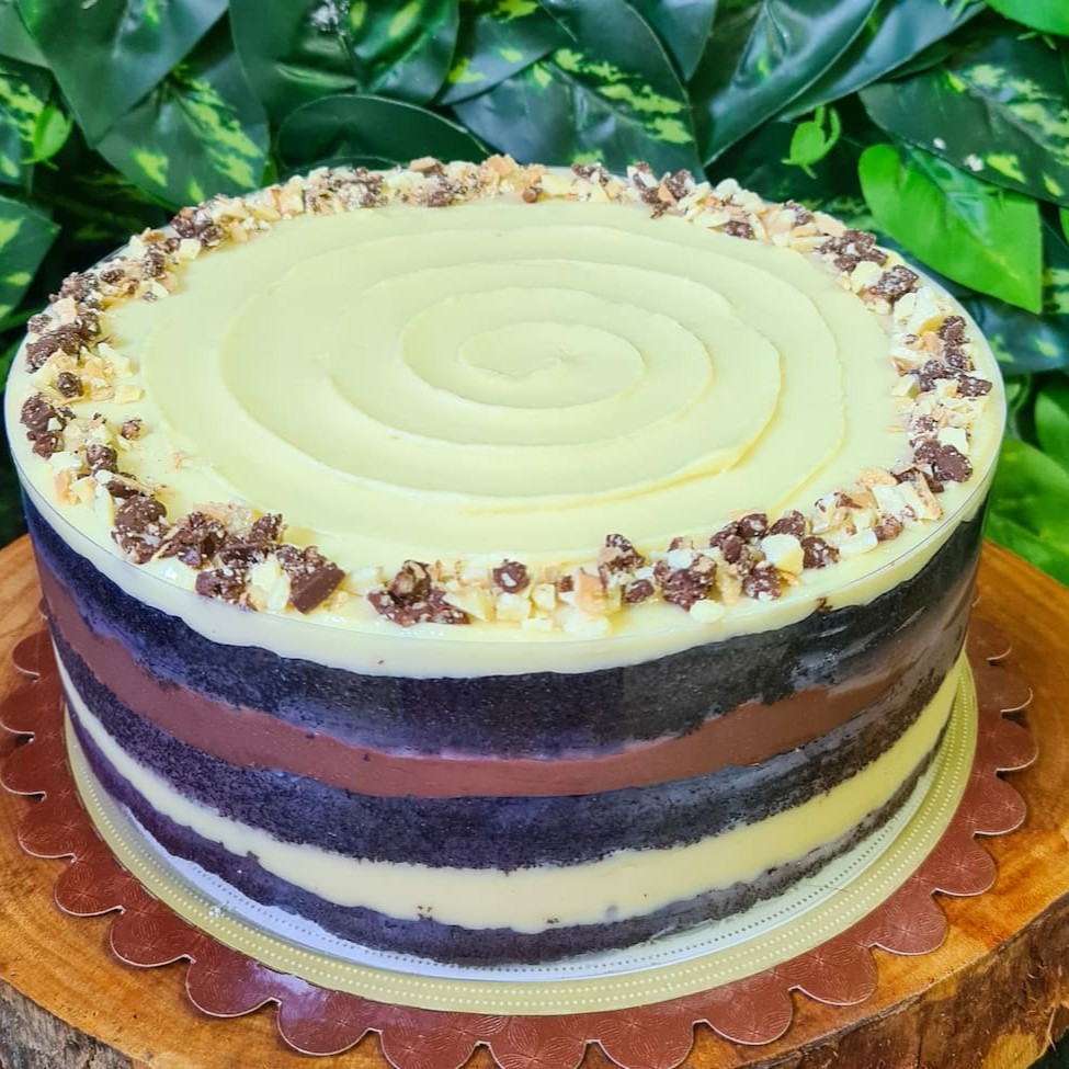 **Atenção: Produto Congelado Para Melhor Transporte** Massa 100% cacau belga, recheada com brigadeiro de chocolate branco, pedaços de Ouro Branco, brigadeiro belga e coberto com ganache de chocolate branca. Pensa na perfeição de fatia!!! Aproximadamente 1,7kg, em torno de 15 fatias festa, aro 20. Produto Enviado Congelado.