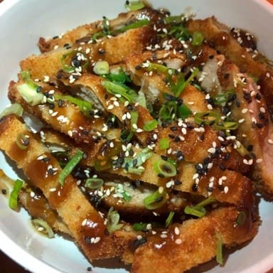 Lombo suíno temperado e empanado  na Panko, cortado em tiras, servido ao molho teriaki e gergelim.