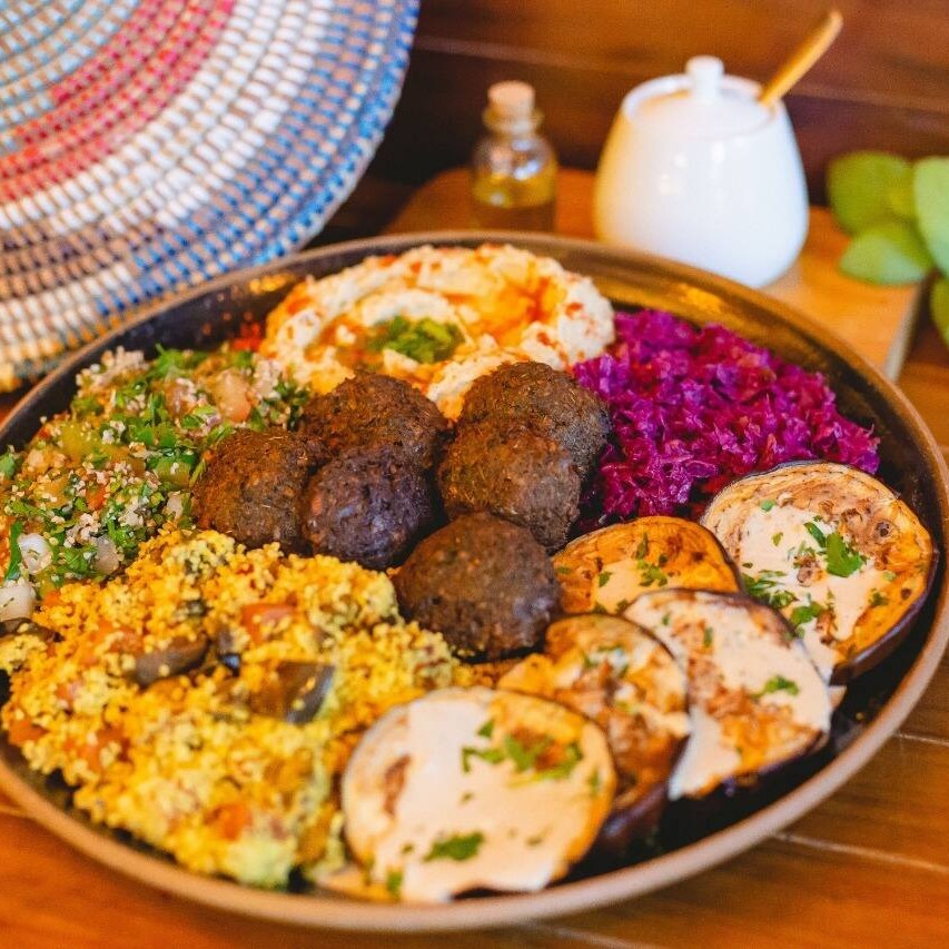 Falafel, berinjela em rodelas com tahine, tabule, picles de repolho roxo, homus e babaganoush