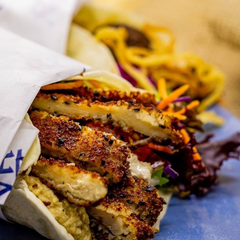 Pão folha, frango empanado, homus, mix de folhas e molho de alho da casa