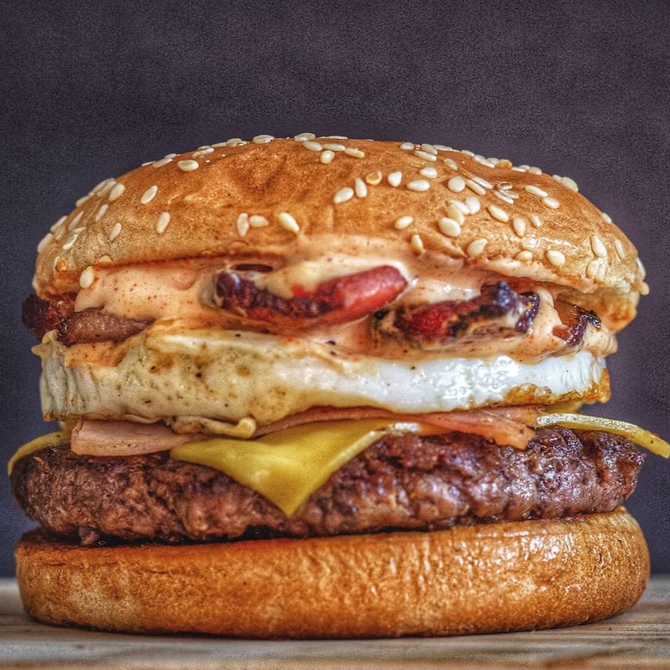 Pão com gergelim, carne artesanal 90g, queijo, presunto, bacon, ovo e molho especial