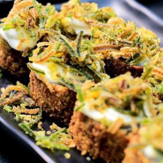 Hotholl de crisp de batata doce é um enrolado recheado de salmão por dentro e nori por fora empanado com farinha Panko frito e crocante finalizado com creame chessee e crisp de alho poró