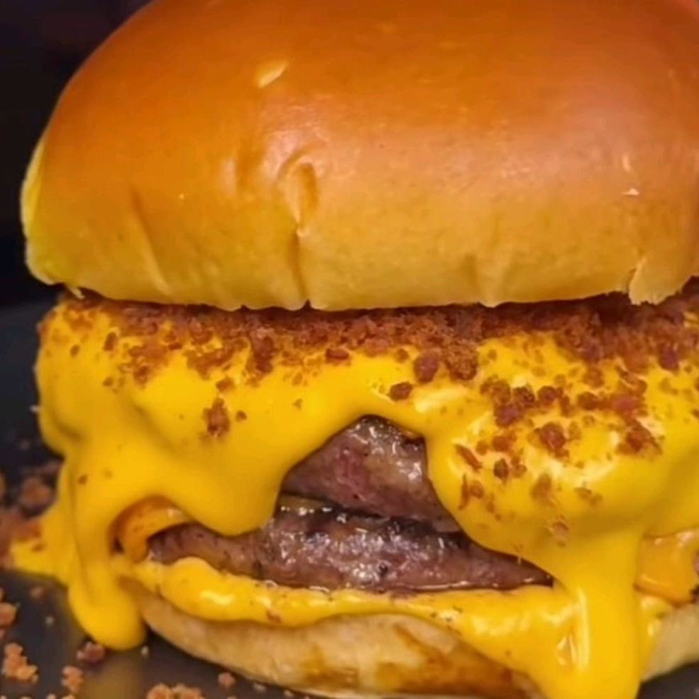 Pão artesanal, duas carnes de hambúrguer artesanal e cheddar e Bacon e cebola caramelizada