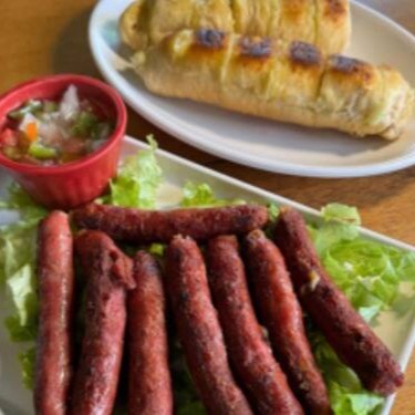 Linguiça de costela é acompanhada por nosso famoso pão de alho, que agrega um sabor único e marcante à experiência.