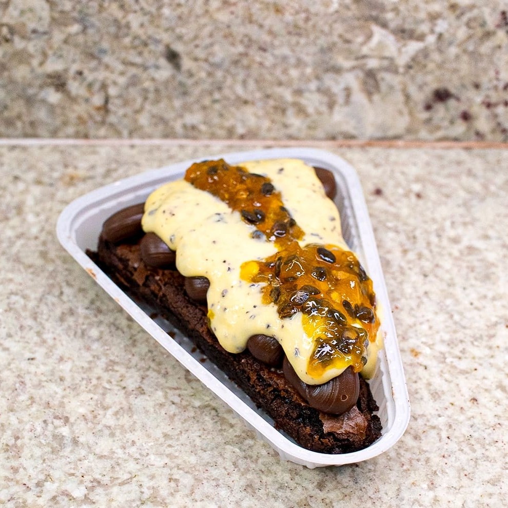 Uma explosão de sabores que você não vai querer perder!    Nossa fatia de brownie supremo maracujá é feita com brownie macio, coberta por brigadeiro cremoso, mousse de maracujá e finalizada com uma calda gourmet irresistível. O equilíbrio perfeito entre doce e azedinho em cada pedaço!    Não deixe passar, peça o seu e experimente essa delícia! . . . . . . . .  #Browniesupremo #Maracujágourmet #Sobremesaperfeita #Saborirresistível #Explosãodesabores