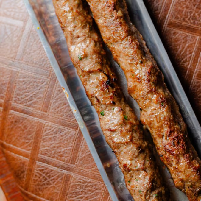 2 espetos grandes de kafta de cordeiro, temperados à moda árabe com hortelã e especiarias. Acompanha nosso vinagrete de romã, que traz frescor e um toque agridoce especial para equilibrar o sabor marcante do cordeiro.