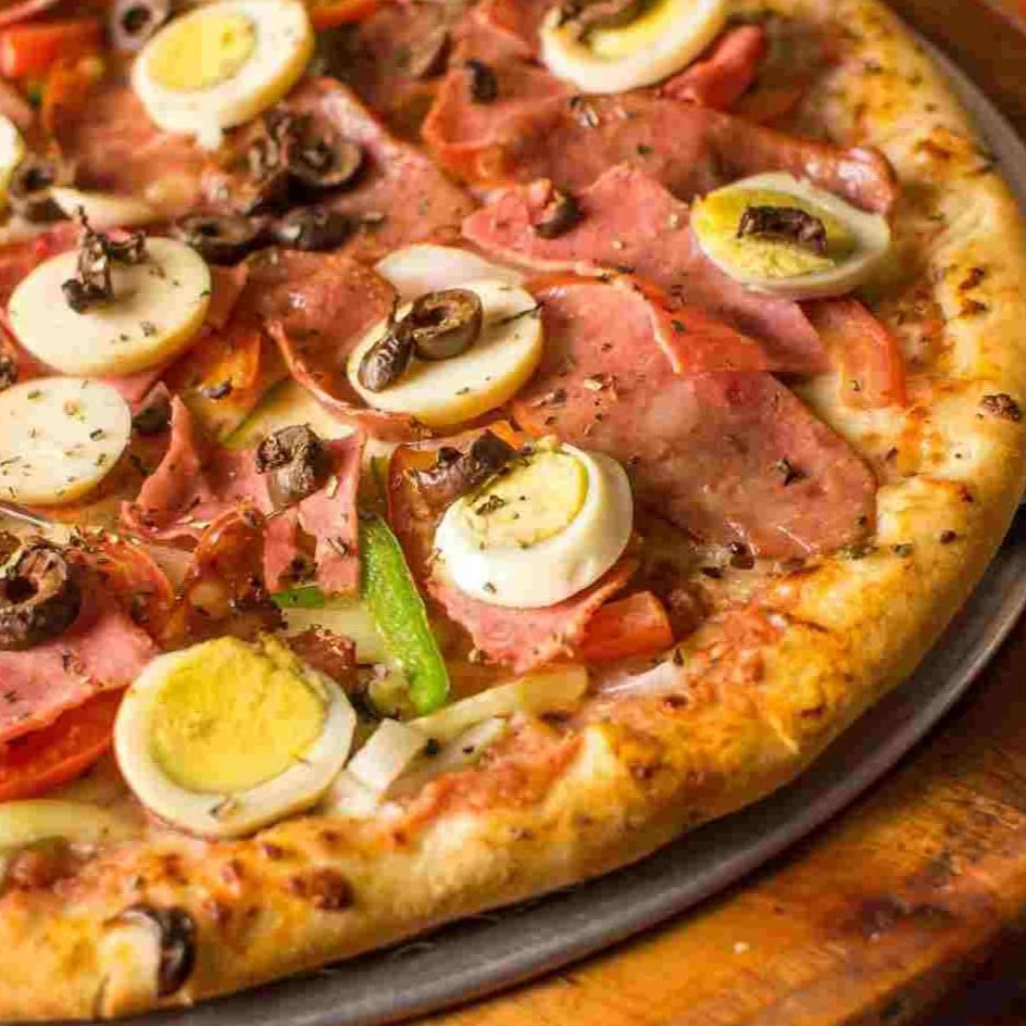 Molho de tomate, mussarela, cebola, tomate, pimentão, presunto, calabresa, azeitona preta e ovos.