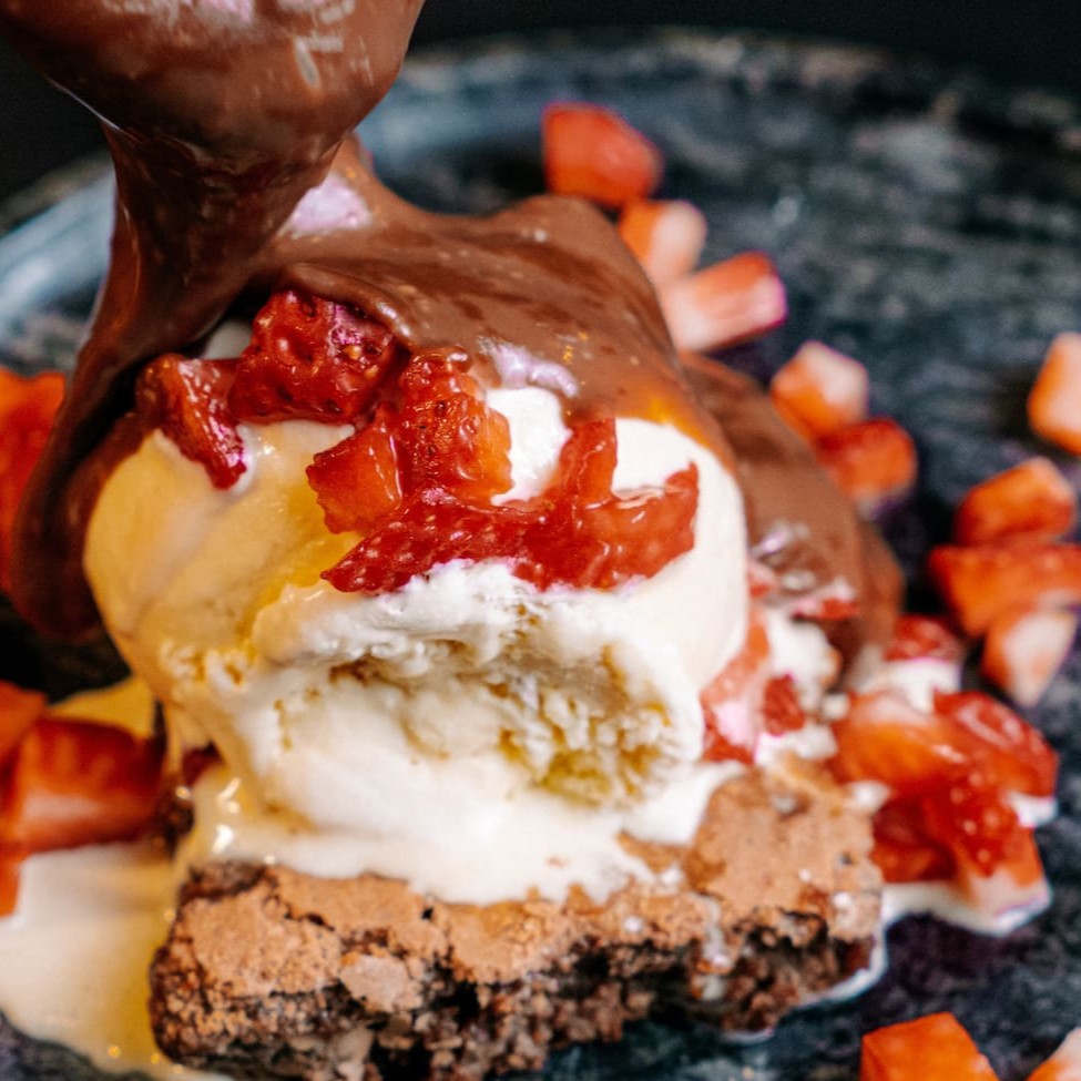 Deliciosa sobremesa de brownie com ganache e geléia de morango, e um maravilhoso sorvete Kibon sabor creme
