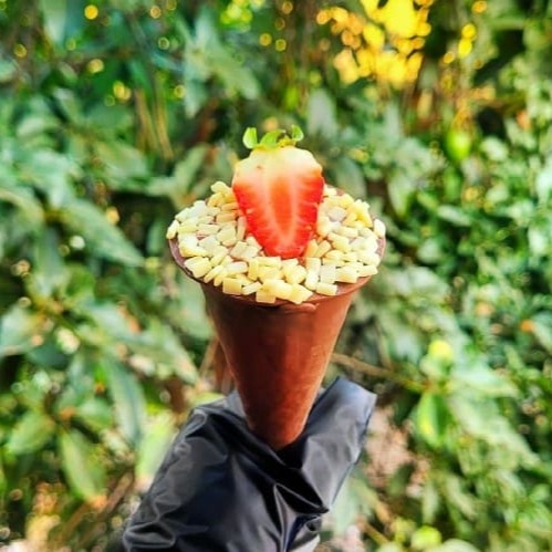 Cone Trufado com recheio de Ninho e pedaços de morango finalizado com granulado chocolate branco e morango. (Peso aproximado 80gr)