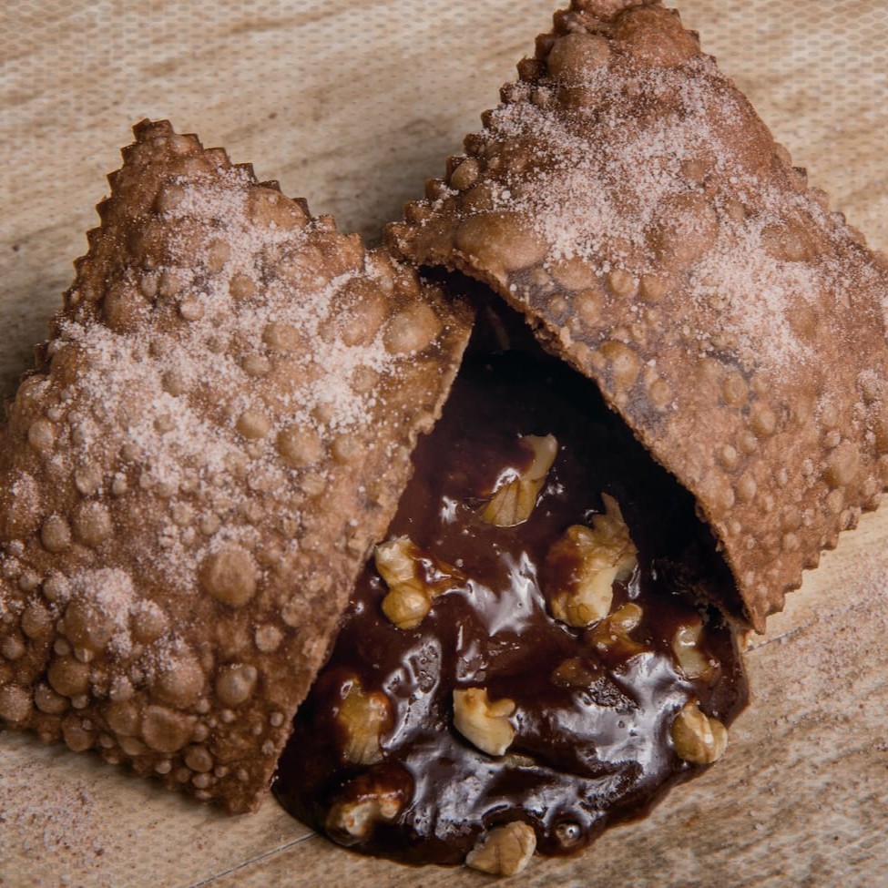 Delicioso pastel polvilhada no açucar e chocolate, recheado com nosso brigadeiro cremoso e nozes crocantes Tamanho 14 X 9,5 Cm
