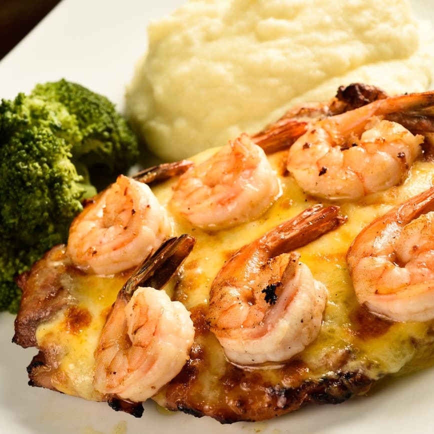 Filé de sobrecoxa de frango assada, mix de queijos, camarões grelhados, escolha dois acompanhamentos.