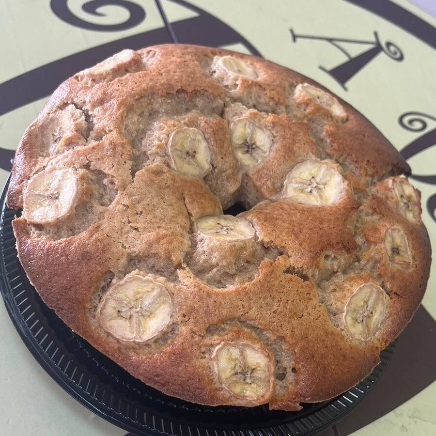 Massa com banana in natura batida, canela e rodelas de banana por cima. Aproximadamente 550gr.