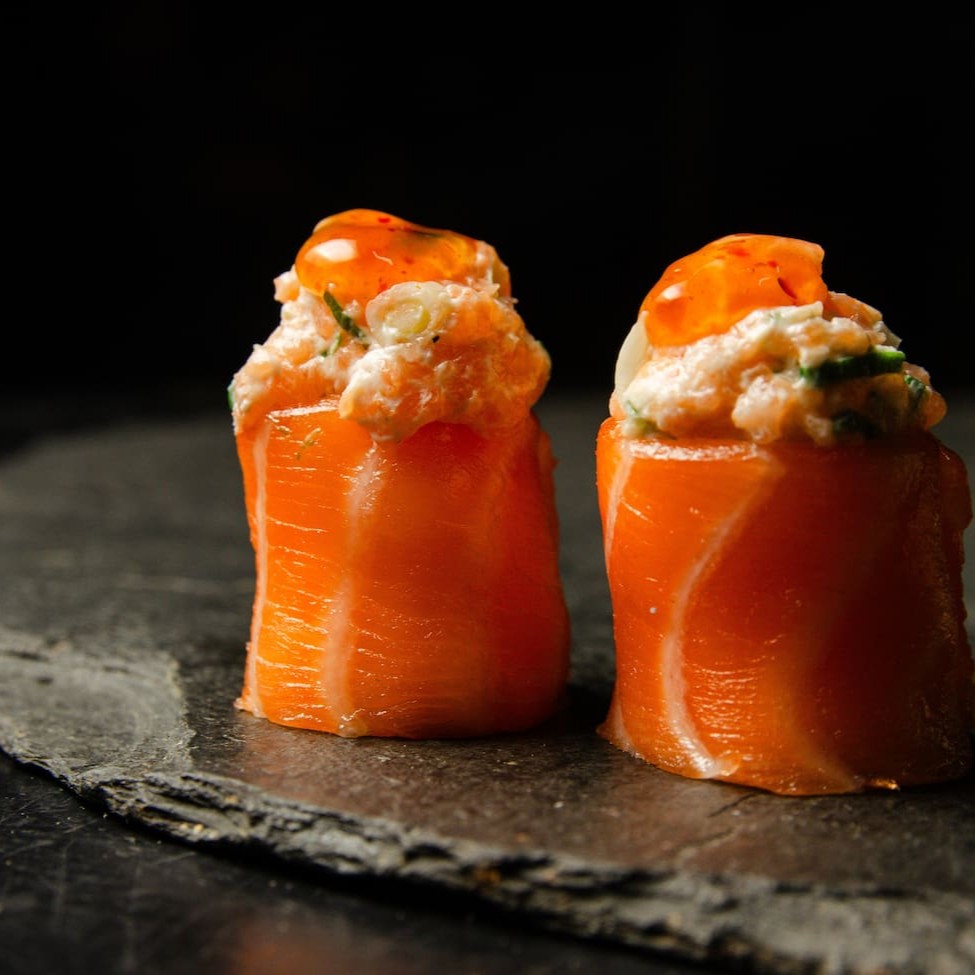 Salmão enrolando arroz com cream cheese, tartar de salmão e um toque de pimenta sweet chilli sauce.