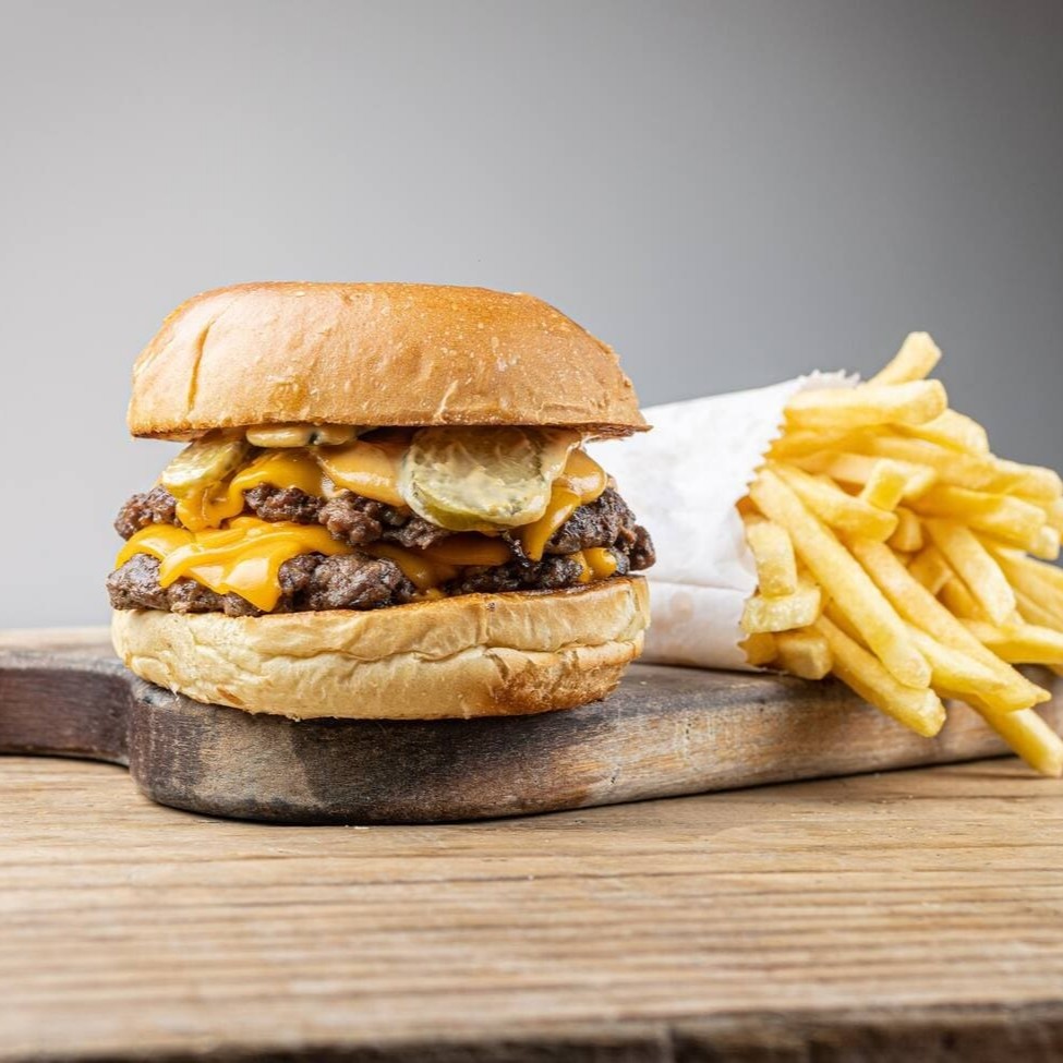 Pão brioche, 2 carne smash de 80g, queijo cheddar, molho especial e picles de pepino caseiro. Acompanha fritas super crocantes!