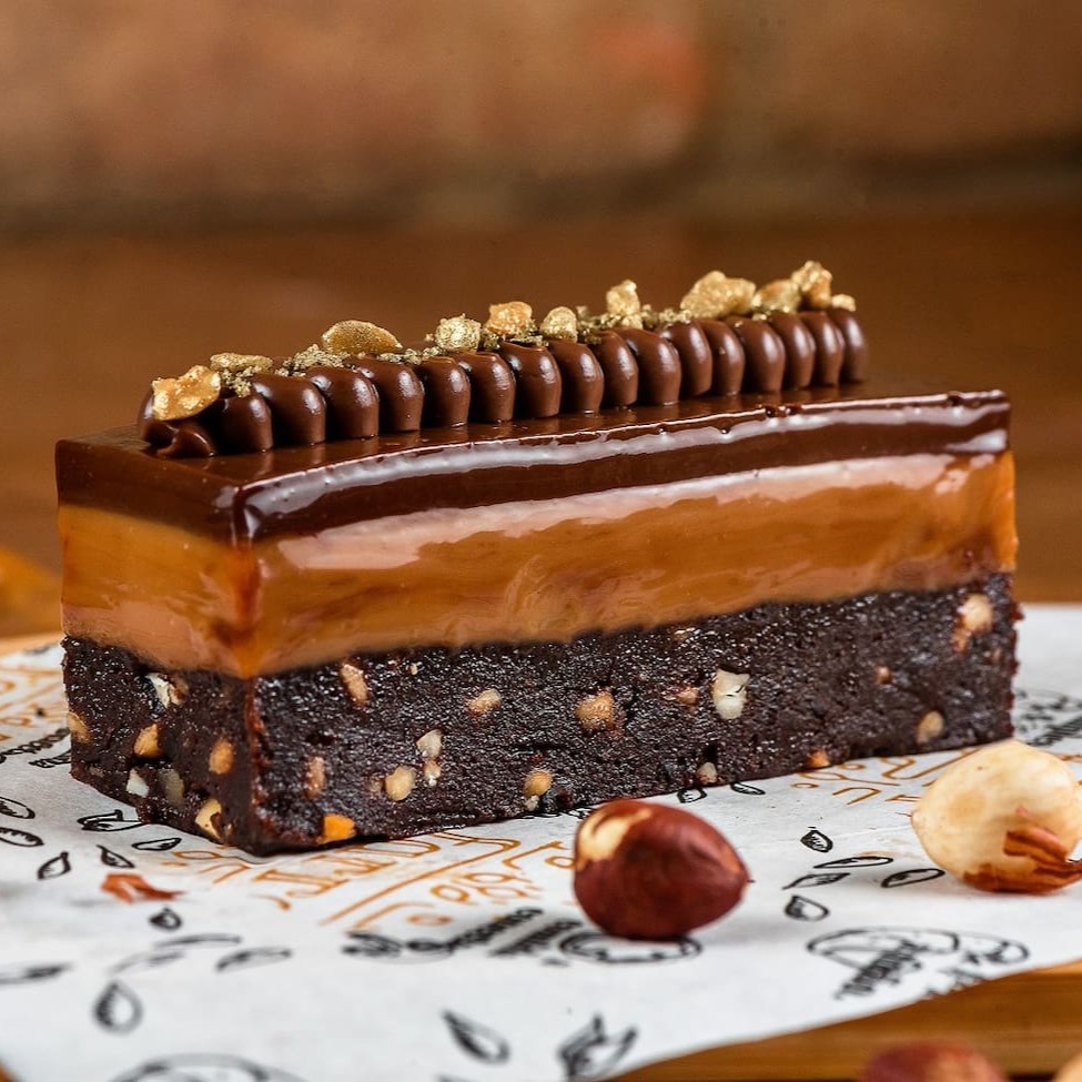 Base de bolo de chocolate meio amargo, chocolate branco, caramelo salgado e finalizado com ganache de café.