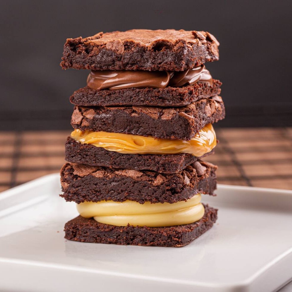 Delicie-se com nossos inconfudivéis brownies feitos com chocolate de alta qualidade, com uma casquinha crocante por fora e um interior incrivelmente molhadinho. Escolha o seu sabor favorito: