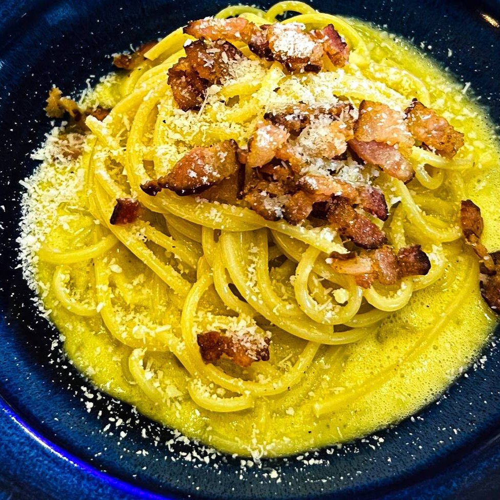 Espaguete Carbonara preparado com ovo caipira, guanciale de qualidade, queijo pecorino autêntico e um toque de pimenta do reino. Uma combinação perfeita de sabores italianos tradicionais em uma refeição rica e irresistível. Experimente o verdadeiro sabor da Itália!