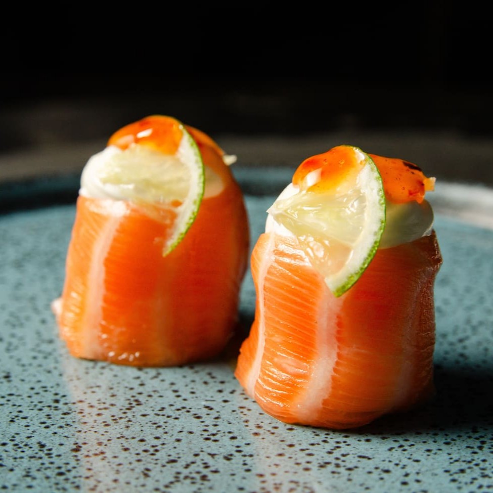 Salmão enrolando arroz com cream cheese e um toque de limão com pimenta sweet chilli sauce.