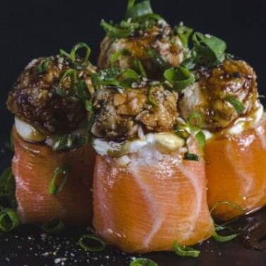 Enrolado de salmão com arroz, creeam cheese, pasta especial de skin, gergelim e molho teriaki.

Uma explosão de sabores em cada pedaço! Arroz temperado envolvido por fatias frescas de salmão, recheado com cream cheese e nossa exclusiva pasta especial de skin (pele crocante de salmão). Finalizado com gergelim levemente tostado e um delicioso toque de molho teriyaki, que traz equilíbrio entre o doce e o salgado. Uma combinação sofisticada, cremosa e crocante que vai conquistar seu paladar!