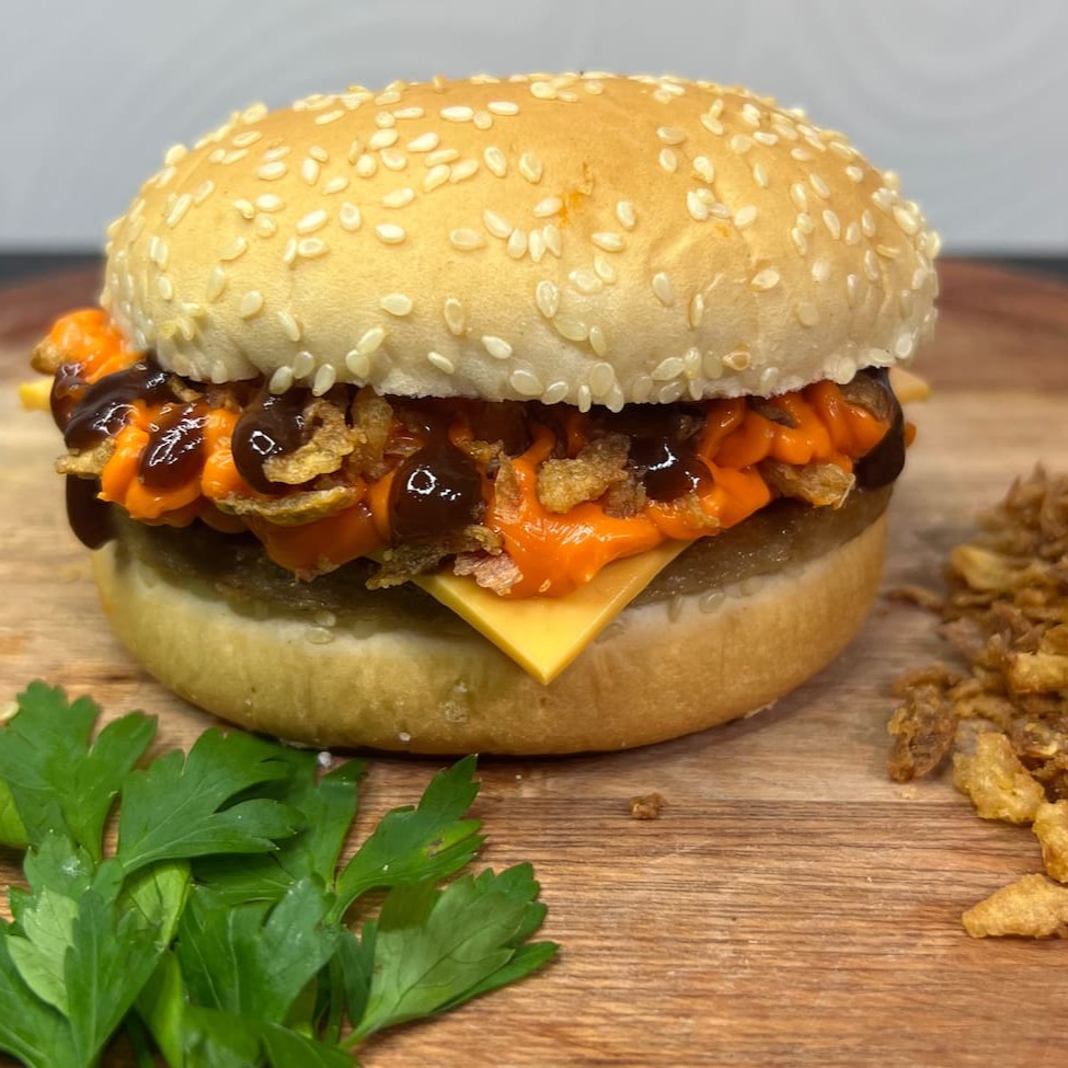 Pão, carne, queijo, cheddar cremoso, cebola crispy e molho barbecue.