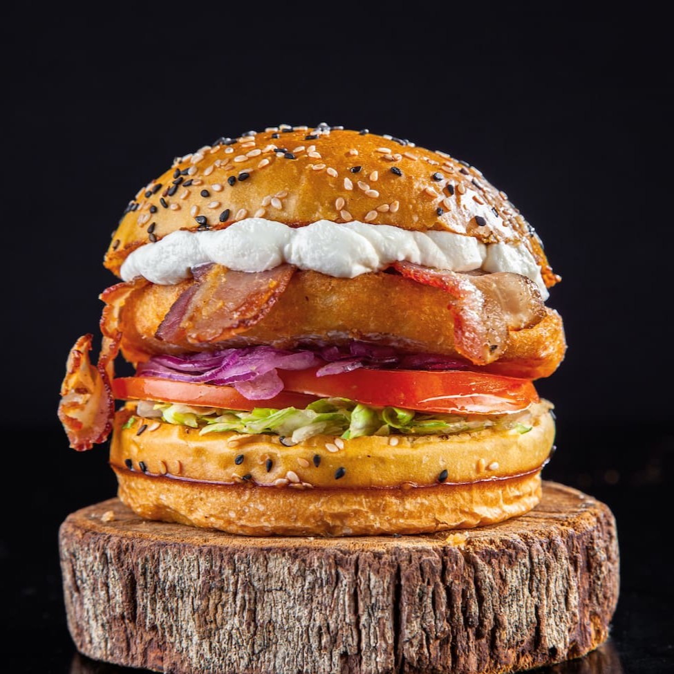 Pão de Brioche Gergelim, hamburguer de frango chicken supreme Seara, camada generosa de Cream cheese de qualidade, fatias de bacon , alface americana, cebola roxa e tomate frescos e maionese surreal