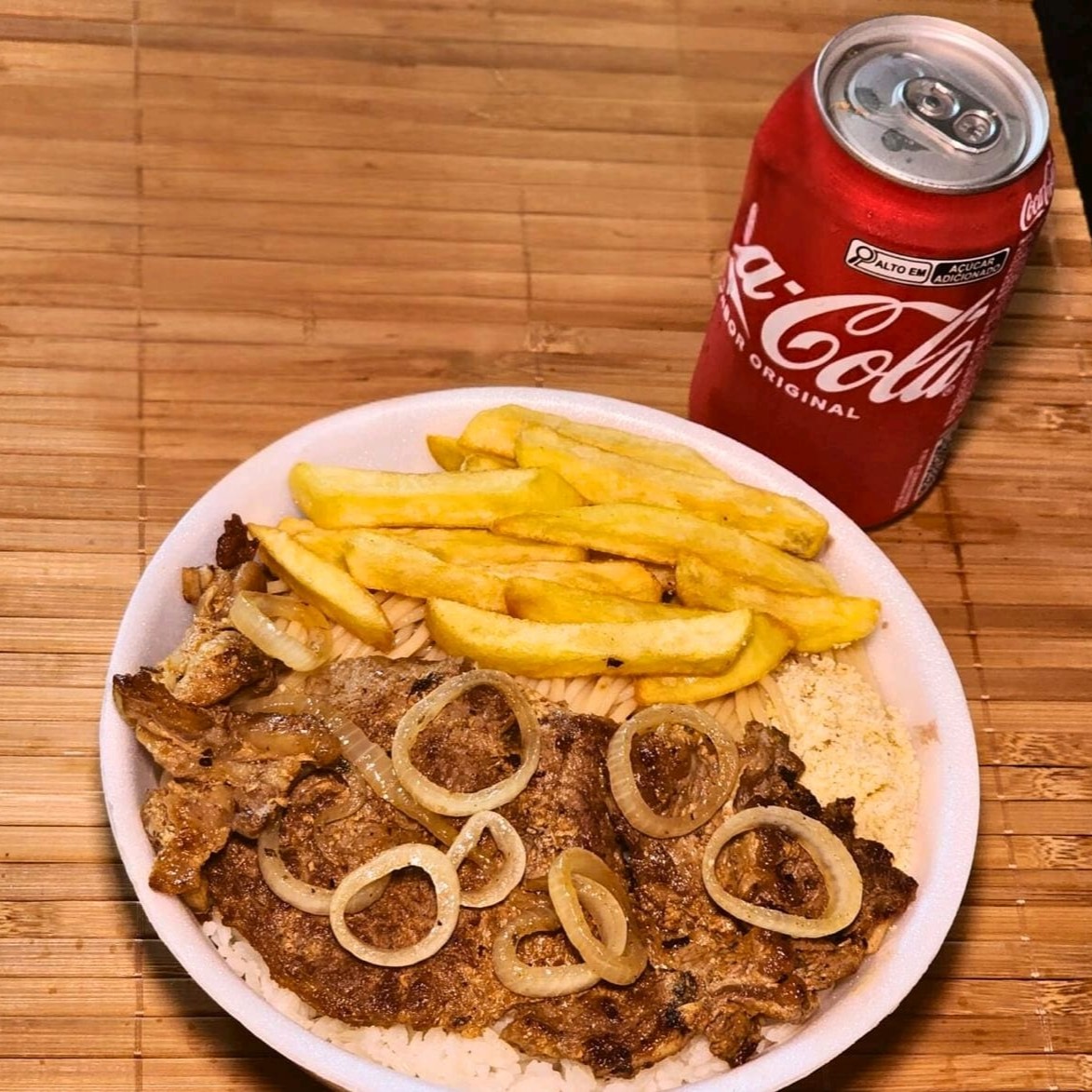Um delicioso bife de contra filé acebolado com batatas fritas crocantes, acompanhado de arroz branco soltinho, feijão preto cremoso bem temperado, macarrão espaguete al dente e farofa crocante caseira.