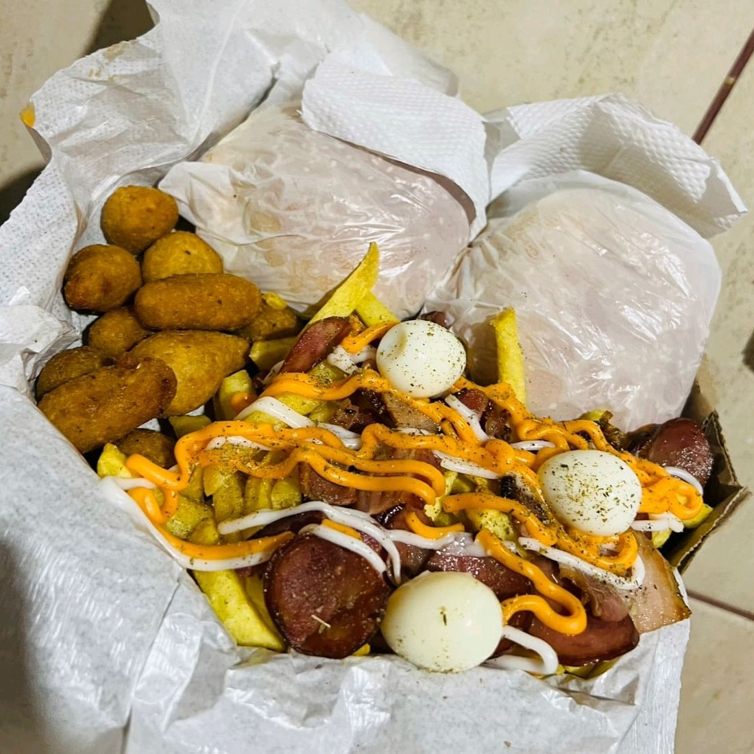 2 x-tudos, batata c/cheddar, Catupiry, bacon, calabresa, orégano, ovo de codorna e salgadinhos