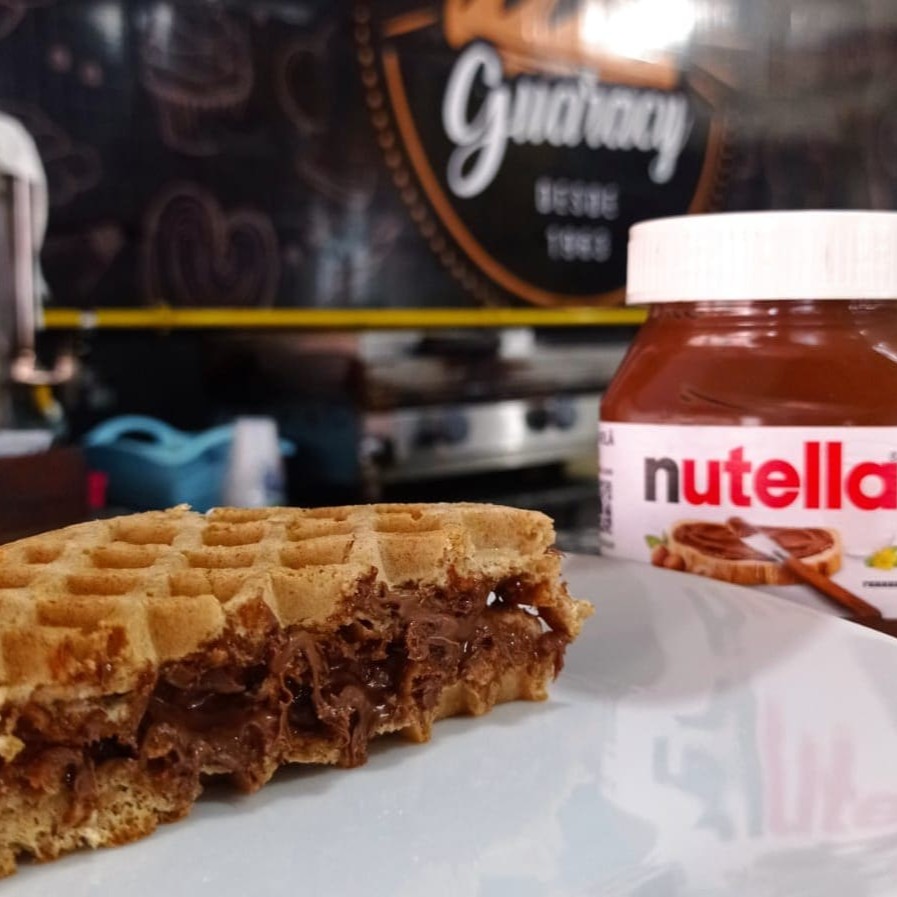 Desfrute do nosso Waffle com Nutella, uma exclusividade Guaracy. Este prato reúne a textura crocante do waffle, disponível nas versões integral ou tradicional, com o recheio irresistível da Nutella. A combinação perfeita de sabor e textura se unem neste prato, criando uma experiência culinária deliciosamente inesquecível. A cada mordida, o sabor intenso da Nutella se funde de maneira harmoniosa com o waffle, proporcionando um prazer único ao paladar. Experimente essa delícia!