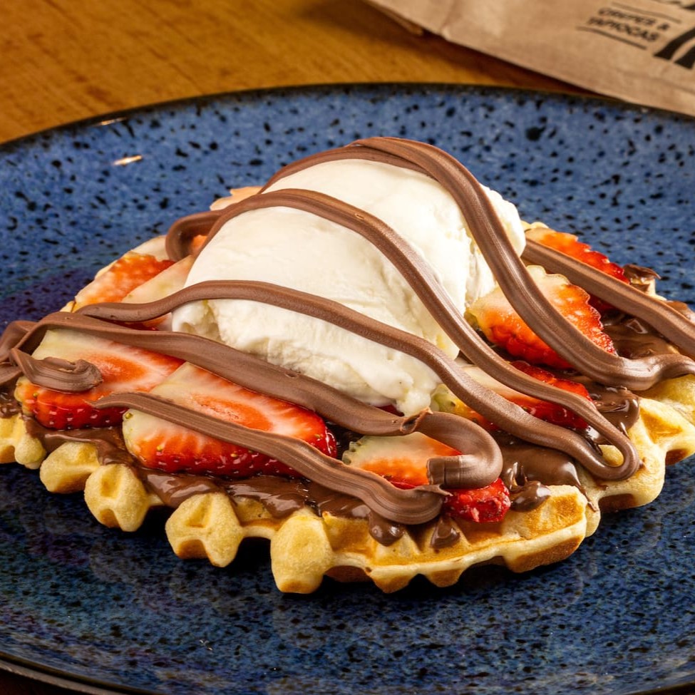Nosso delicioso Waffle com Nutella, morango, sorvete e linhas de chocolate. O sorvete é enviado em uma embalagem a parte.