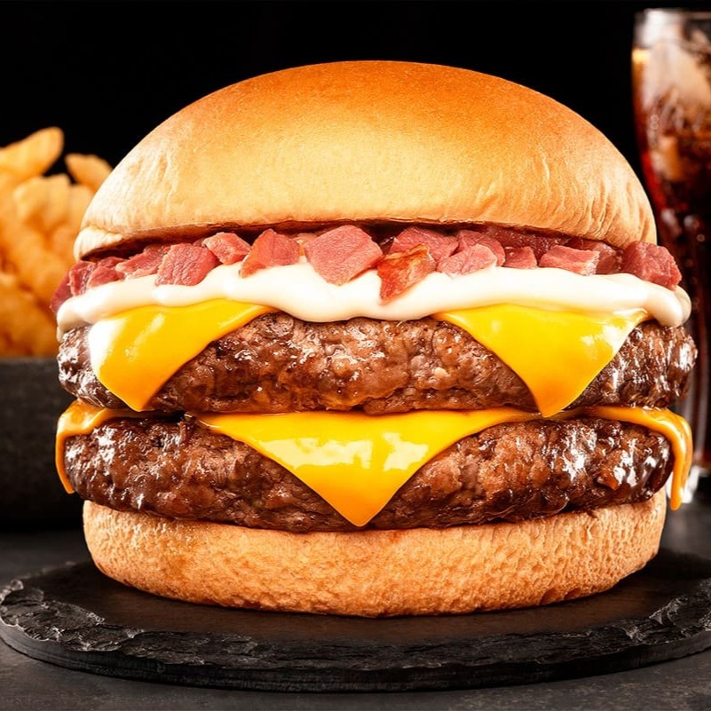 Pão, 2 Blends de 160g (Total 320g), Queijo Cheddar, Nossa Maionese de alho, Bacon artesanal defumado em cubos.