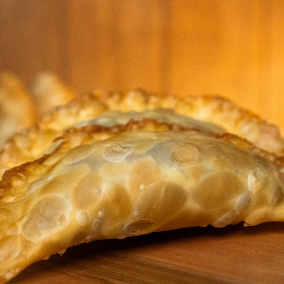 Queijo, presunto e orégano. Mistura saborosa em um pastel de massa fina e crocante.
