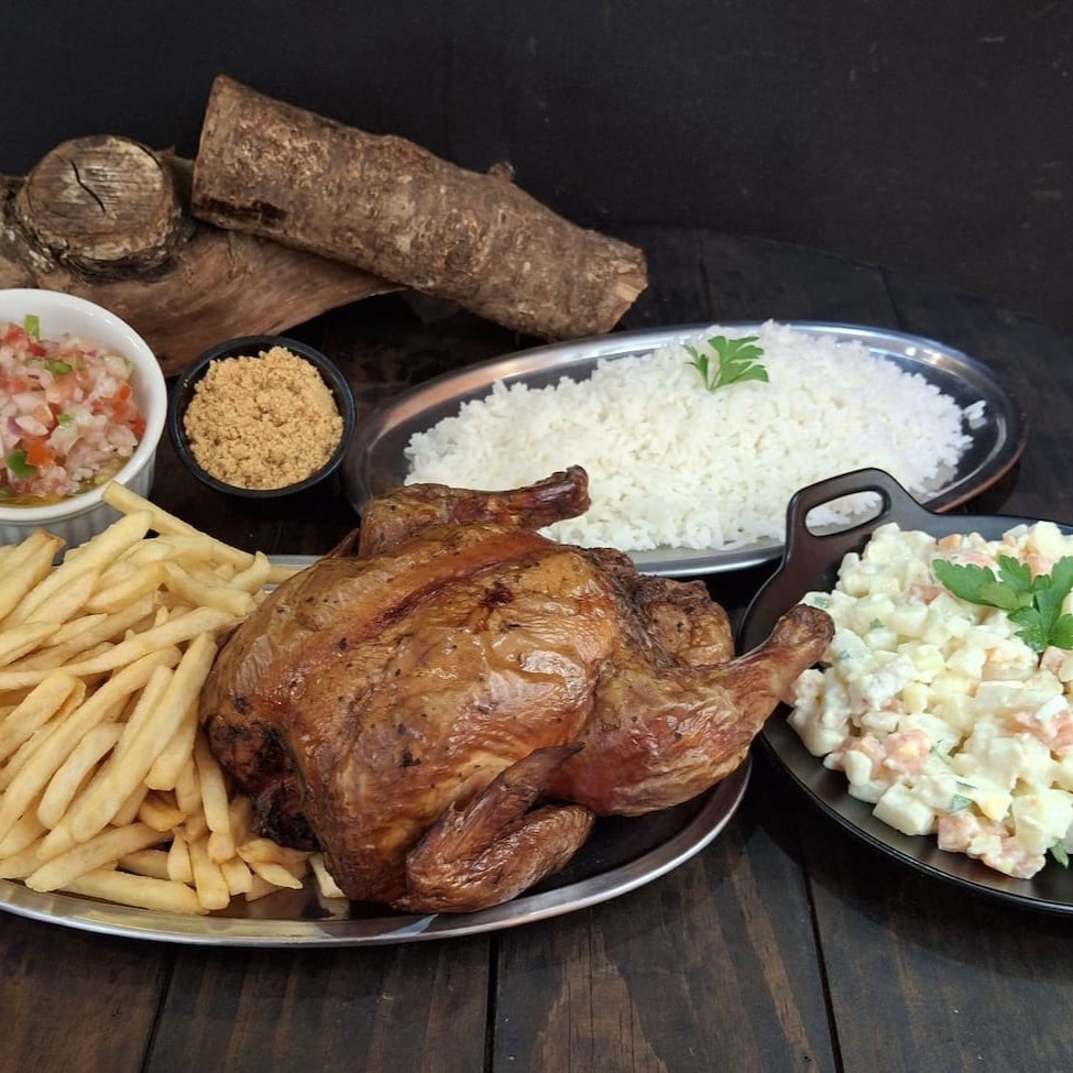 Frango Assado Defumado na lenha frutífera, 500g de batata frita ou aipim frito, 500g de arroz, farofa de bacon, molho à campanha e 500 g de maionese.  Obs: Nosso frango apresenta a coloração avermelhada devido a ação da fumaça (defumação)