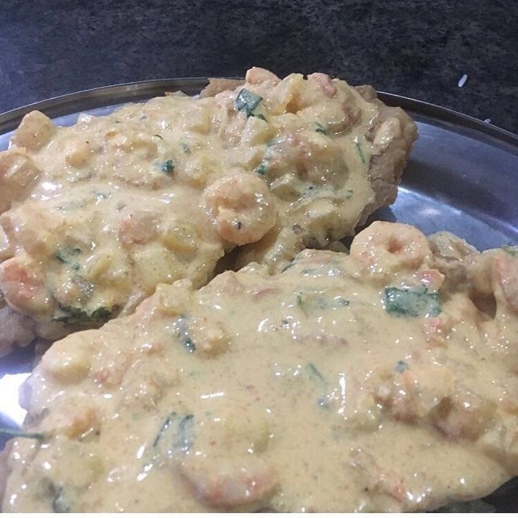 Iscas de filé de peixe com molho de camarão e cobertura de mussarela.