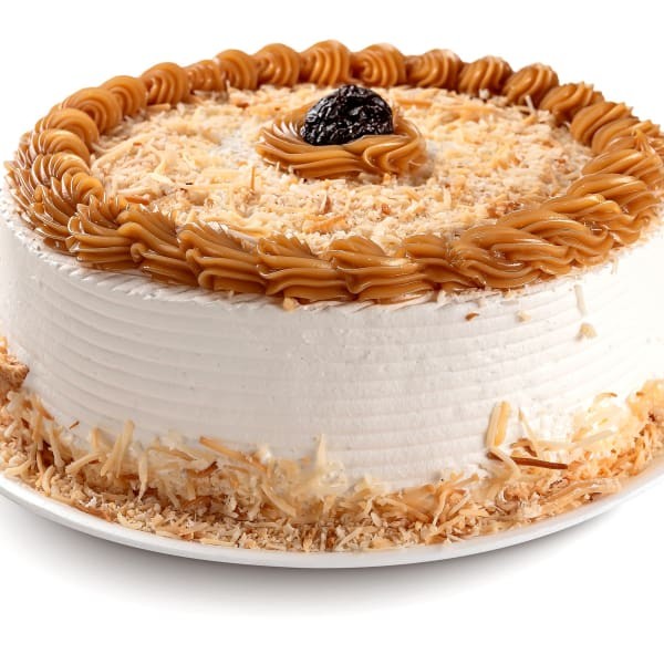 Bolo branco com recheio de doce de leite com ameixa, coberto com chantilly e decorado com coco queimado, ameixa e doce de leite.