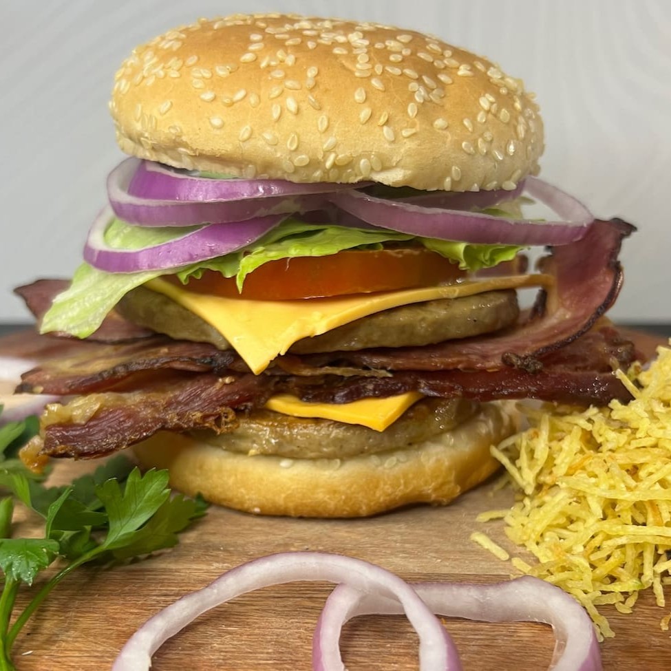 Pão, 2 carnes,2 fatias de queijo mussarela, bacon em cubos, alface americana, tomate, cebola roxa, batata palha e molho especial da casa.