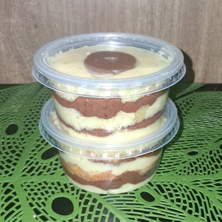 Um pote recheado de puro prazer! Esse bolo no pote traz camadas irresistíveis de massa fofinha intercaladas com um creme sedoso de leite Ninho e o sabor marcante do creme de avelã. A combinação é perfeita: o doce delicado do Ninho abraça o sabor intenso e envolvente do chocolate com avelã, criando uma experiência cremosa e sofisticada. Finalizado com uma generosa camada brilhante de creme de avelã no topo, é a sobremesa dos sonhos para os amantes de sabores ricos e indulgentes.