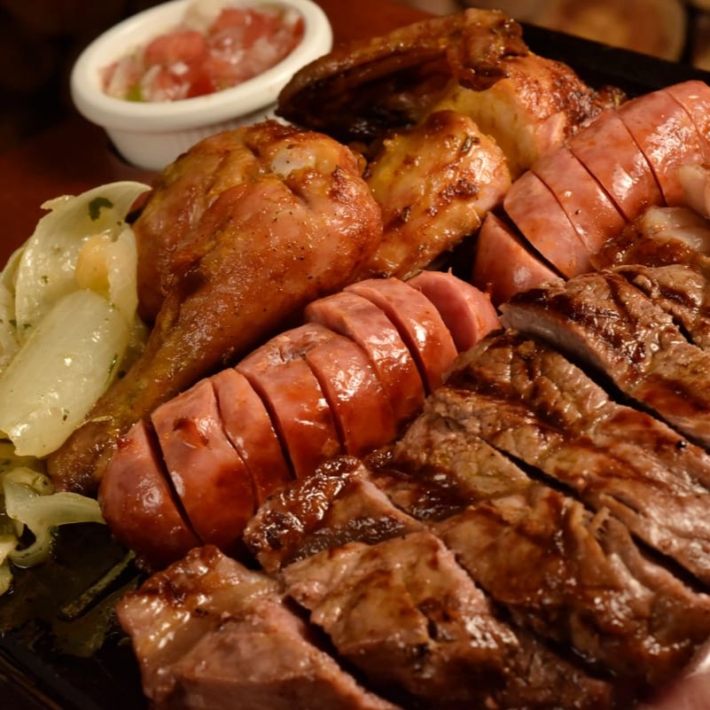 Chorizo 300g, uma linguiça de pernil, uma fatia de lombo suíno, meio galeto. Opção à campanha ou dois acompanhamentos