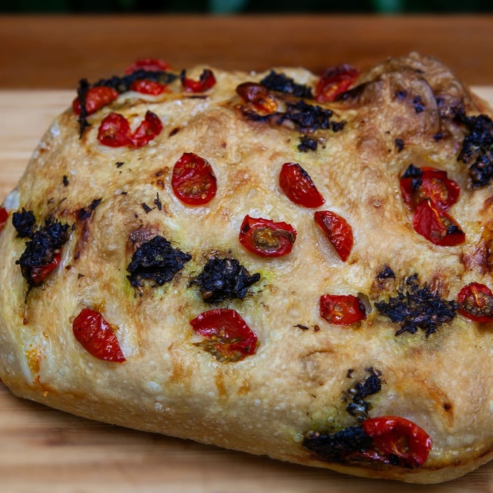 Massa de fermentação natural com 100% de hidatratação, com molho pesto da casa e pedaços de tomate cereja.