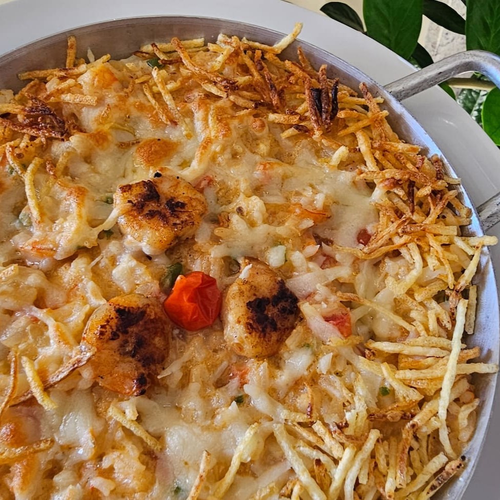 Arroz de camarão refogado com nosso molho branco e leite de coco. Finalizamos com queijo gratinado e batata palha.